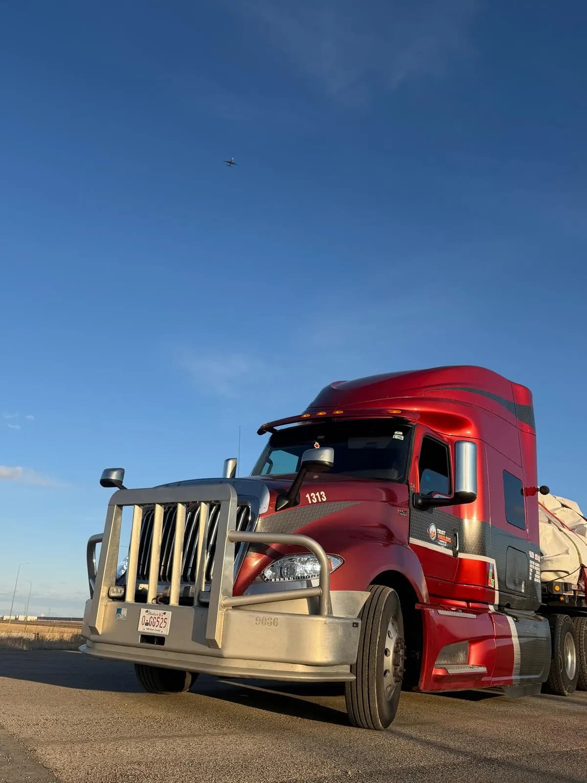 Red Trust Haulers truck 1313 with a loaded flatbed trailer